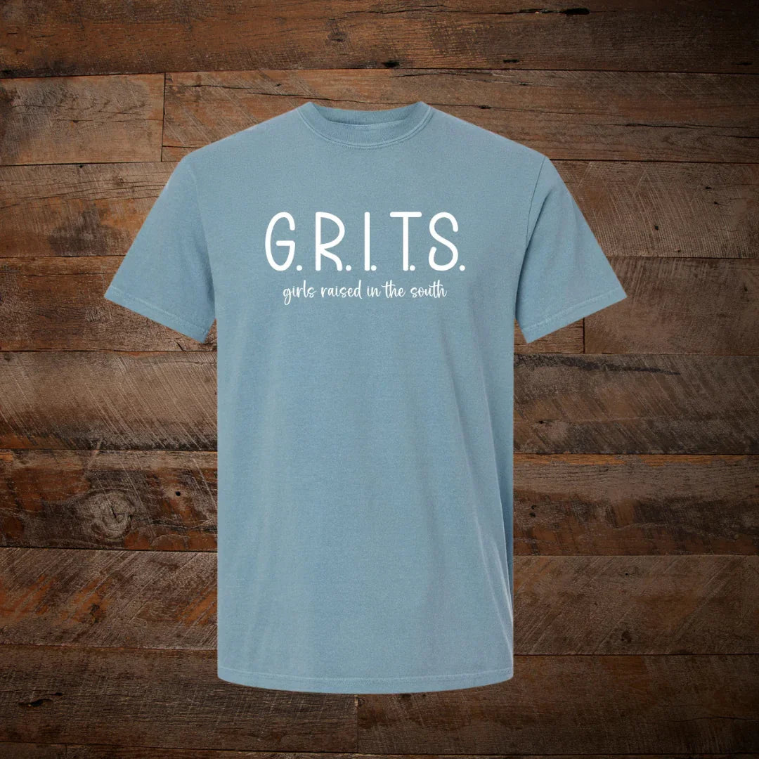 Blue t-shirt with G.R.I.T.S. girls raised in the south text, displayed on wood background