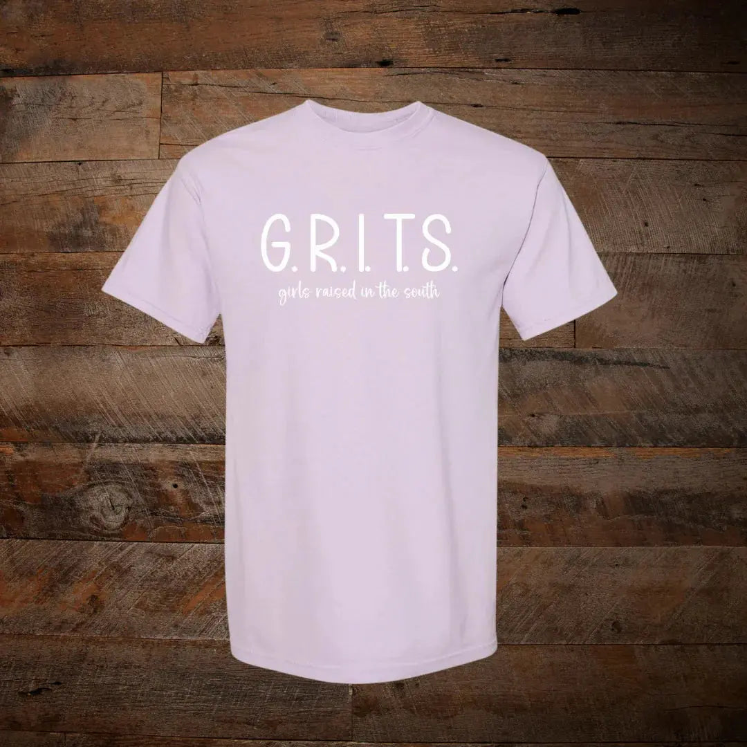 Light lavender t-shirt with 'G.R.I.T.S. girls raised in the south' text on wooden background
