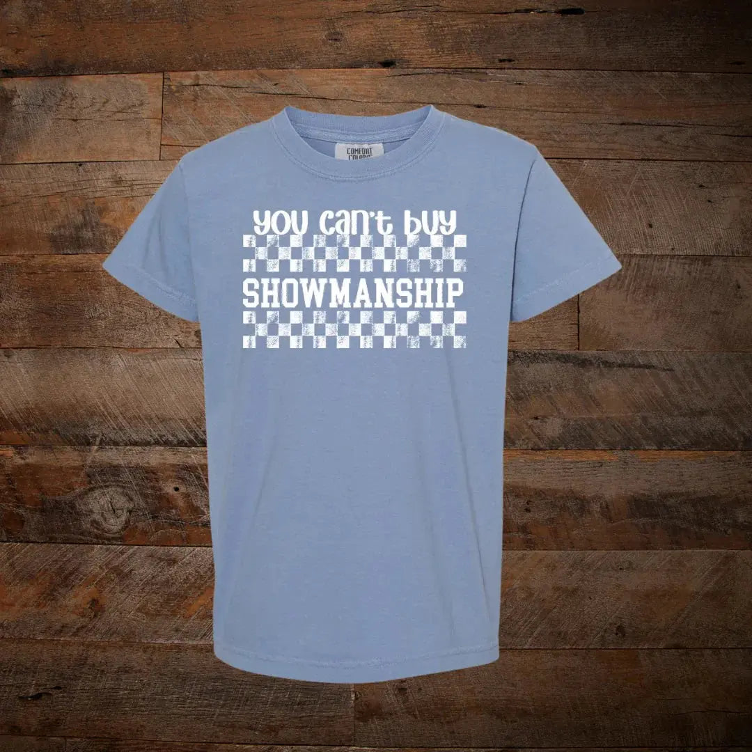 Blue t-shirt with 'You can't buy showmanship' text and checkered pattern on wood background