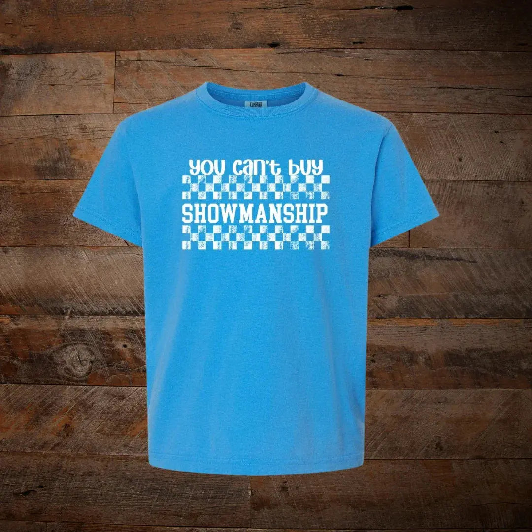 Blue unisex t-shirt with 'You can't buy showmanship' and checkered graphic, rustic wood background