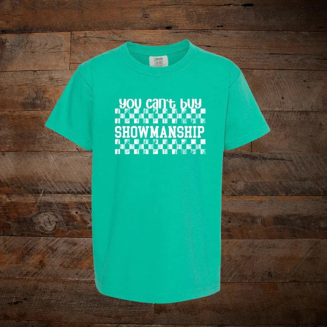 Teal t-shirt with white checkered pattern and 'You Can't Buy Showmanship' text on wood background