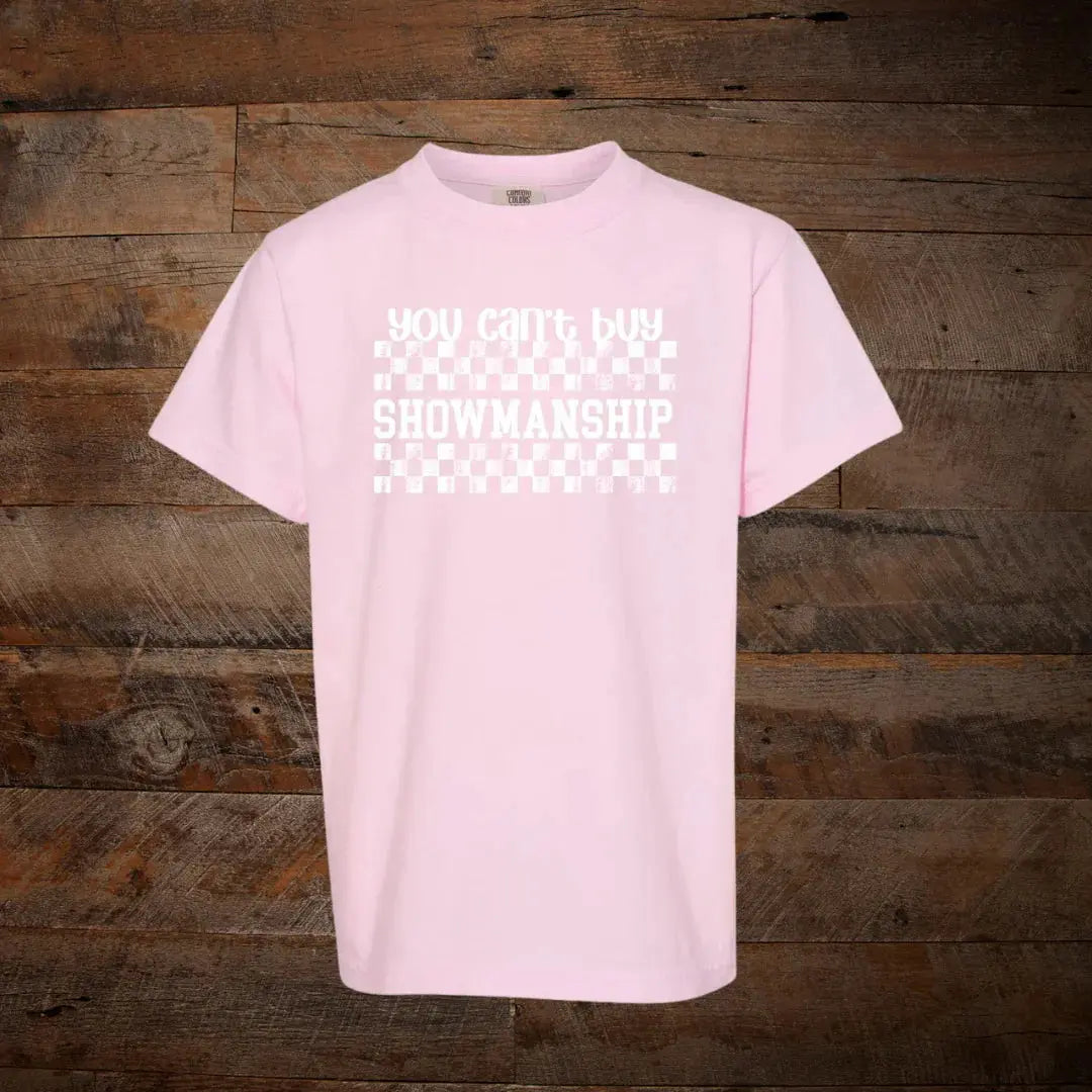 Light pink t-shirt with 'You can't buy showmanship' text and checkered graphic on wood background