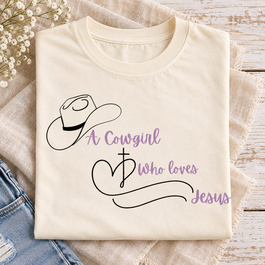 A Cowgirl Who Loves Jesus Ivory tee front on warm linen